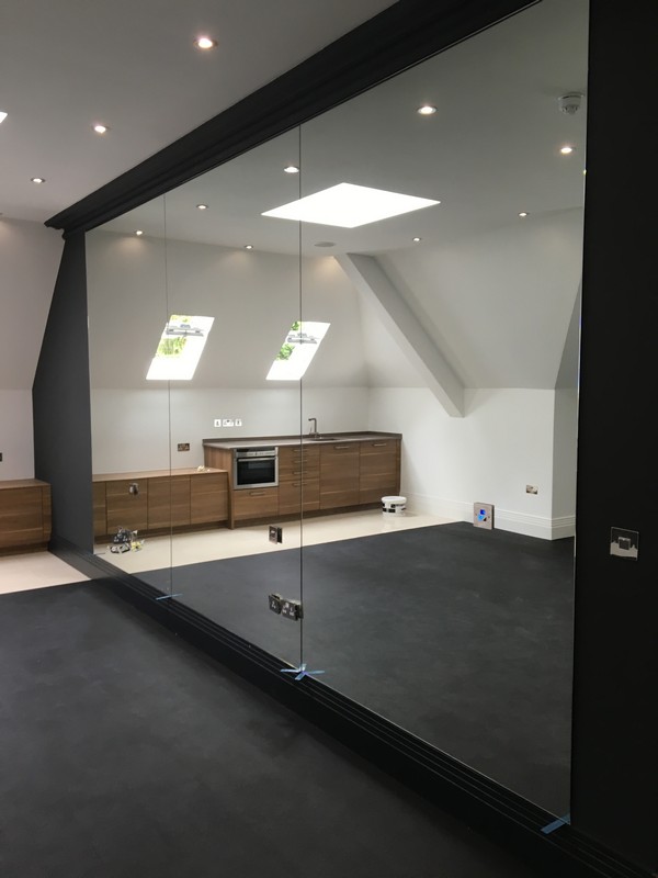 Frameless glass partition in loft conversion by Roehampton glaziers